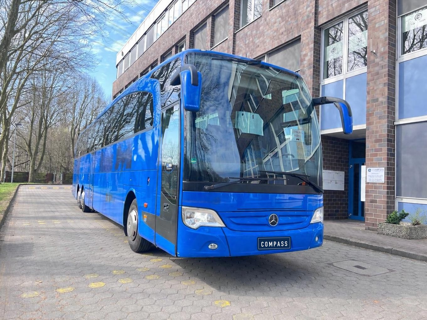 Blue Mercedes-Benz Travego in front of the Compass office